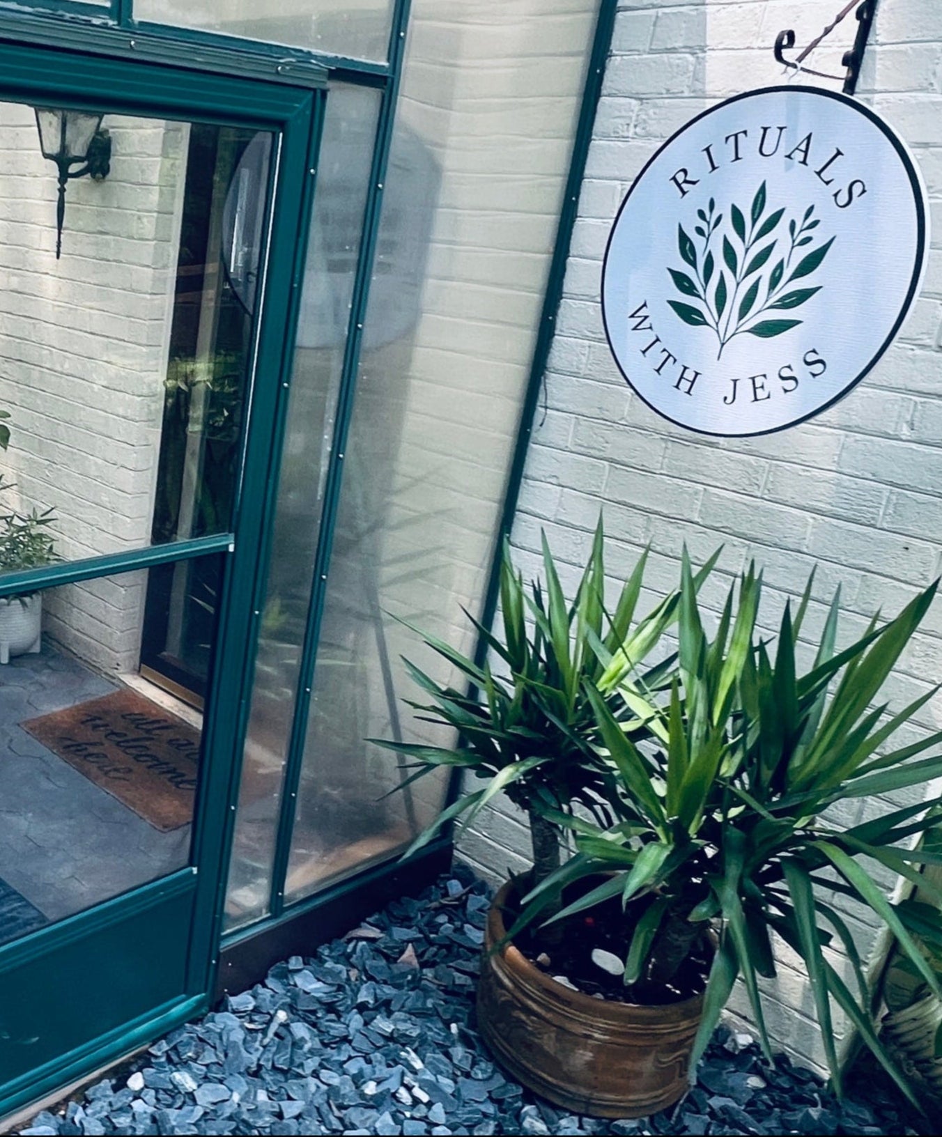 Greenhouse with a door open, showing a patio area outside, and a brand sign on the wall.